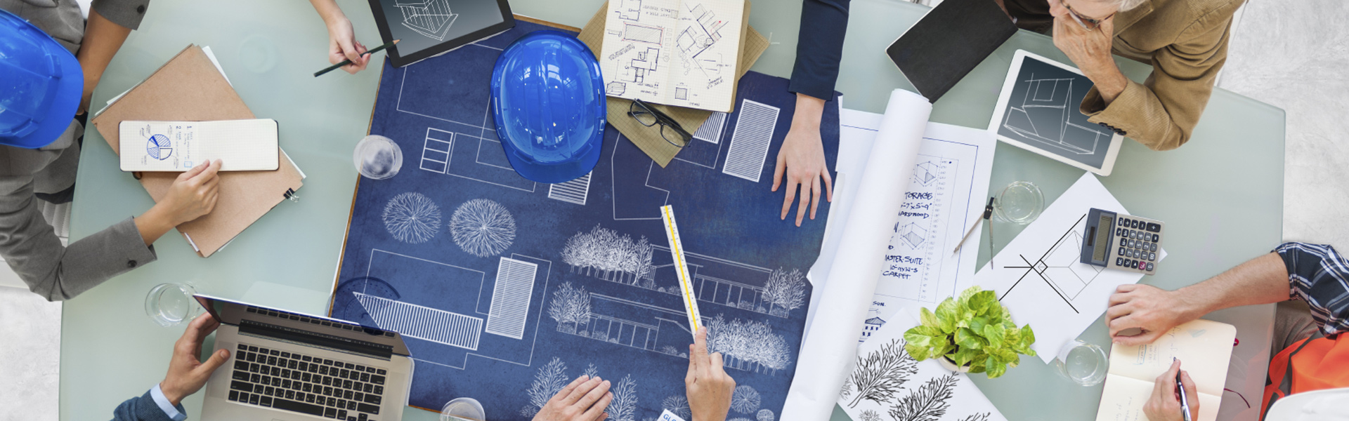 Several employees review blueprints and architectural plans together